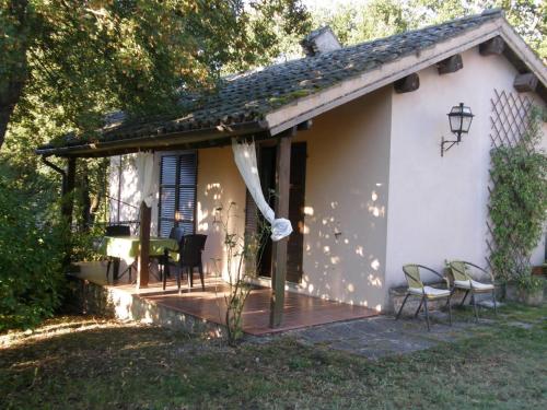 a small white house with chairs and a deck at Ca' le Suore in Cagli