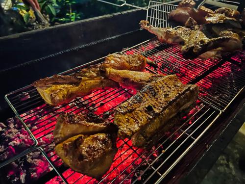 a bunch of meat cooking on a grill at Jade Hotel in Phong Nha