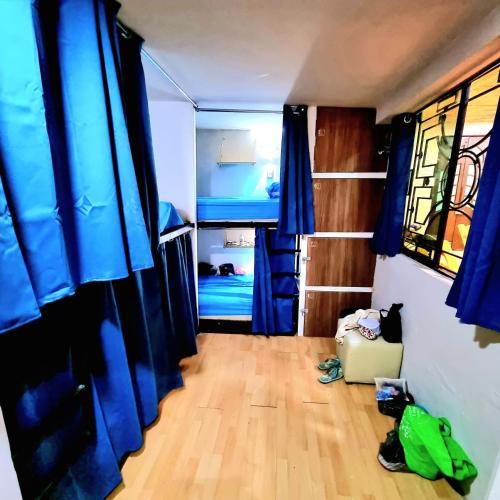 a bedroom with blue curtains and a wooden floor at HOM Roma in Mexico City