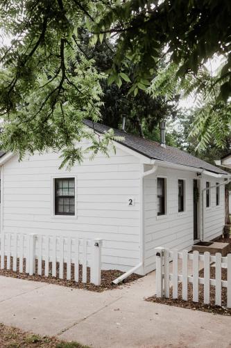 a white house with a fence in front of it at Spearfish Cottages in Spearfish