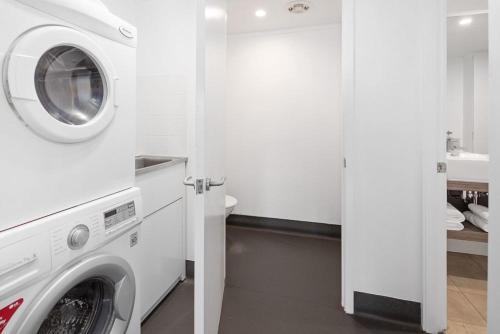 a white laundry room with a washer and dryer at Corrigans Cove in Batemans Bay