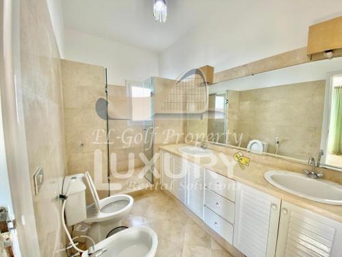 ein Badezimmer mit zwei Waschbecken und zwei Toiletten in der Unterkunft Villa 9 ph-5 with 4 Bed Room in Hurghada