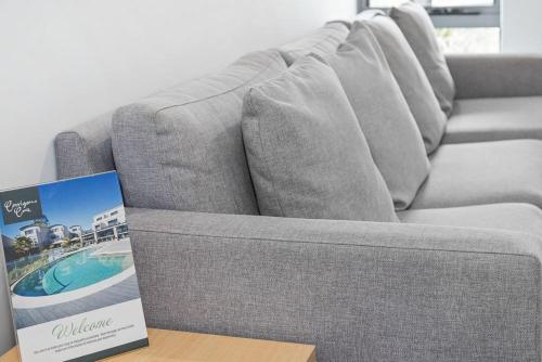 a couch sitting on top of a table with a book at Corrigans Cove in Batemans Bay