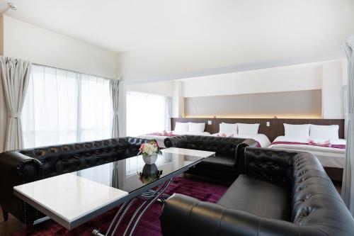 een woonkamer met een bank en een bed bij Ideal Fukushima in Osaka