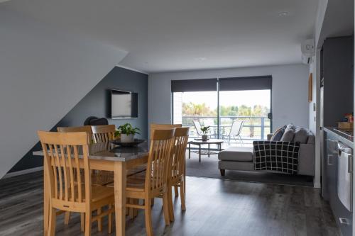 a kitchen and dining room with a table and chairs at Corrigans Cove in Batemans Bay
