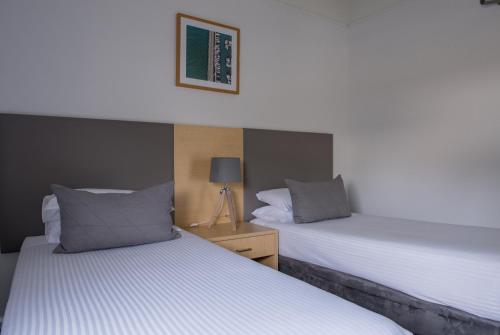 two beds sitting next to each other in a bedroom at Corrigans Cove in Batemans Bay