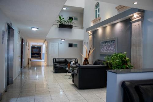 a hallway with couches and plants in a building at Hotel Qualitel Plus in Morelia