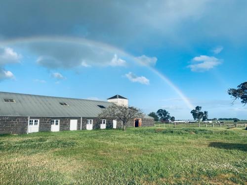 a rainbow in the sky over a barn at Mount William Station in Willaura