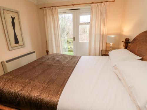 a bedroom with a large bed and a window at Coquet View Cottage in Morpeth