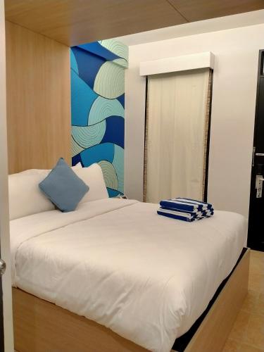two beds in a room with a mural on the wall at The Henry Resort Taramindu Laiya in Batangas City