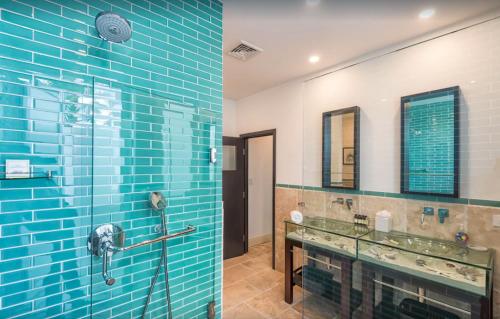 a bathroom with blue tile and a glass shower at The Luxury Villa in Saint Martin