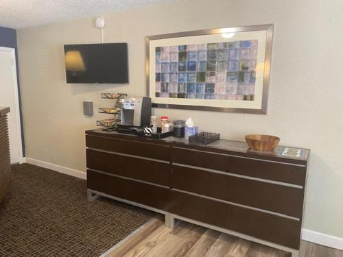 um quarto com uma cómoda e uma televisão na parede em Andy Griffith Parkway Inn em Mount Airy