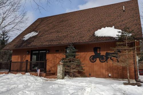 a wooden house with snow on the side of it at Bluebird Manor on the Water, 2 Acres & Amenities in Liberty