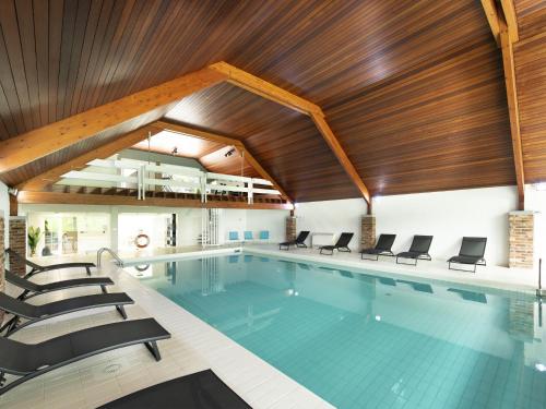 オベルにあるLuxury villa with heated pool near Li geの木製天井の大型スイミングプール