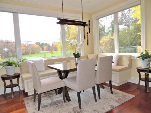 a dining room with a table and chairs and windows at iResidence in Toronto - Unique Mansion - Fantastic Views with Breakfast in Toronto