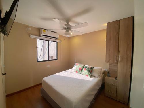 a bedroom with a bed with a ceiling fan at Apartaestudios - Casa Tamarindo in Aracataca
