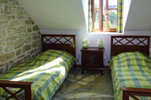 two beds in a room with a stone wall at Semi-detached house, Bénodet in Bénodet