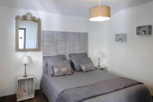 Schlafzimmer mit einem Bett mit Spiegel und Lampen in der Unterkunft Holiday Home, Neville-sur-Mer in Néville-sur-Mer