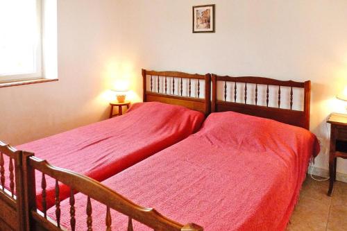 a bedroom with two beds with red sheets at Stone cottage with shared pool, Chambonas in Chambonas