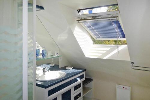 La salle de bains est pourvue d'un lavabo et d'une lucarne. dans l'établissement Villa in Erquy near Emerald Coast Beaches, à Erquy