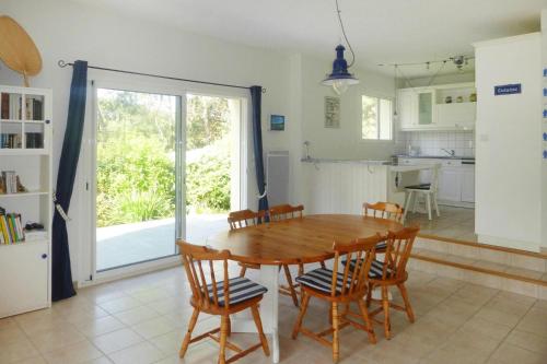 une cuisine et une salle à manger avec une table et des chaises en bois dans l'établissement Villa in Erquy near Emerald Coast Beaches, à Erquy