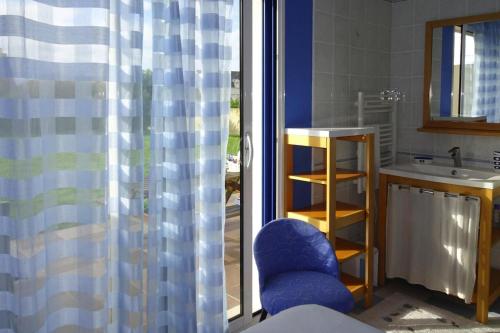 La salle de bains est pourvue d'une chaise bleue et d'un lavabo. dans l'établissement Holiday Home in Le Guilvinec near Sandy Beach, au Guilvinec