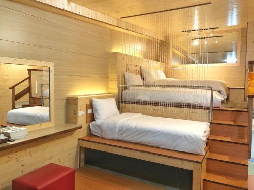 a room with two bunk beds and a mirror at Runners' House Taitung in Changbin