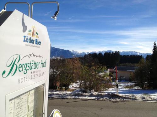 a sign for asteiner inn with mountains in the background at Hotel Bergstätter Hof in Immenstadt im Allgäu