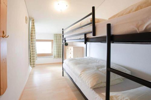 a bedroom with two bunk beds and a hallway at Holiday flats B rlerhof K nigsleiten in Königsleiten