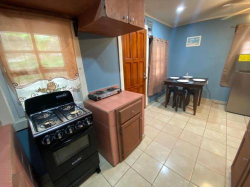 a small kitchen with a stove and a table at Bahia Azul Apartment in Six Huts
