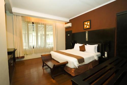 A bed or beds in a room at Sabda Alam Hotel & Resort