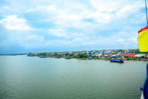 - une vue sur une rivière avec des maisons et des bateaux dans l'établissement Rockmouse Centre River Villa Hoi An, à Hội An