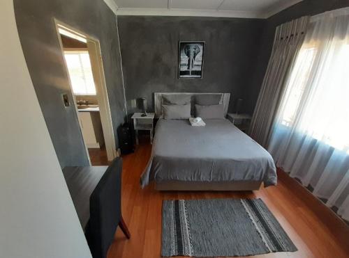 een kleine slaapkamer met een bed en een raam bij The Private and Cosy Guest House 1 in Germiston