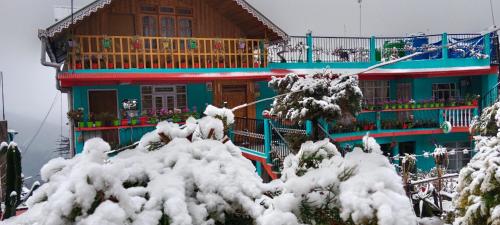 a house with snow covered trees in front of it at Kabiraalaya Homestay in Darjeeling