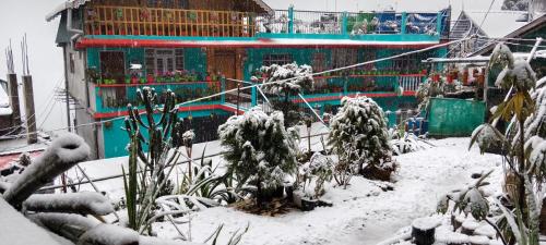 a house covered in snow in front of a yard at Kabiraalaya Homestay in Darjeeling