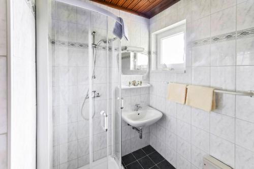 a white bathroom with a shower and a sink at Bungalow in St Kanzian am Klopeler See with a terrace in Unternarrach