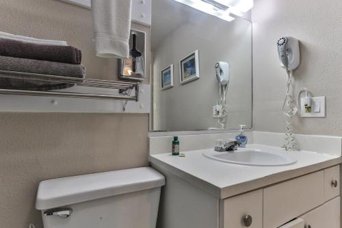 a bathroom with a sink and a mirror at Coastal Waters in New Smyrna Beach