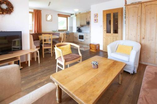 a living room with a table and a kitchen at Holiday flat B rlerhof XXL K nigsleiten in Königsleiten