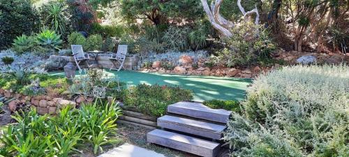 a garden with two chairs sitting in the grass at Camps Bay Loft with Stunning Mountain and Ocean Views in Cape Town
