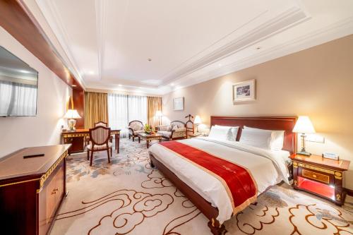 Großes Hotelzimmer mit einem Bett und einem Schreibtisch. in der Unterkunft Maritim Hotel Taicang Garden in Taicang