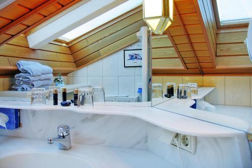 baño con lavabo blanco grande y espejo en Landhaus Salzburg, Dienten, en Dienten am Hochkönig