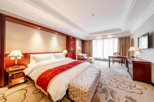 a hotel room with a large bed and a desk at Maritim Hotel Taicang Garden in Taicang