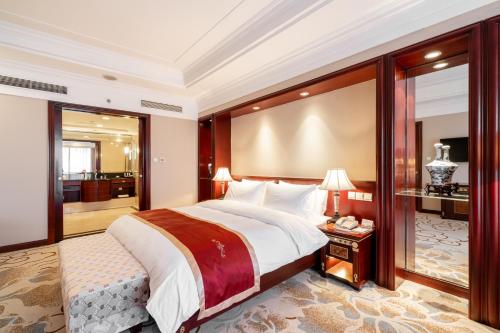 a bedroom with a large bed and a balcony at Maritim Hotel Taicang Garden in Taicang