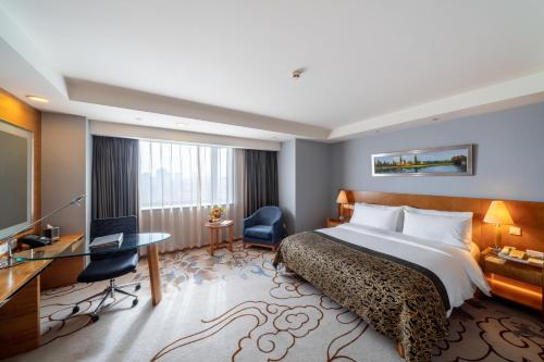 a hotel room with a bed and a desk at Maritim Hotel Taicang Garden in Taicang