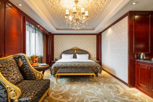 a bedroom with a bed and a chair and a chandelier at Maritim Hotel Taicang Garden in Taicang
