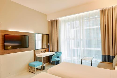 a hotel room with a bed and a desk and a window at Citymax Hotel Business Bay in Dubai