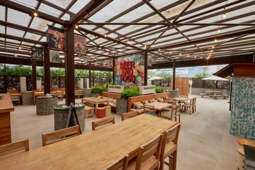 a restaurant with wooden tables and chairs and a roof at Citymax Hotel Business Bay in Dubai
