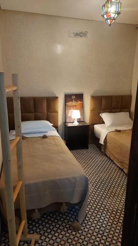 a hotel room with two beds and a fireplace at Auberge RIAD DLIM Tamraght in Tamraght Ouzdar