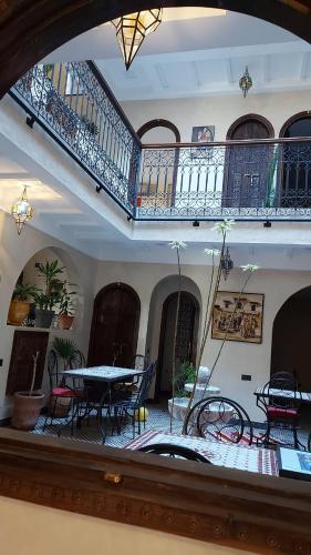 a room with a table and chairs and a balcony at Auberge RIAD DLIM Tamraght in Tamraght Ouzdar