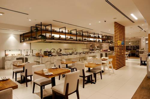 a restaurant with wooden tables and chairs and a counter at Citymax Hotel Business Bay in Dubai